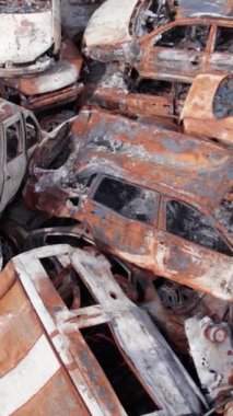 Bu stok dikey video Irpin, Bucha bölgesinde bir kurşun ve yanmış araba dökümü gösteriyor.