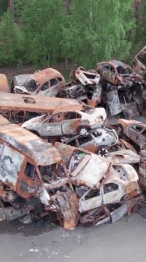 Bu stok dikey video Irpin, Bucha bölgesinde bir kurşun ve yanmış araba dökümü gösteriyor.