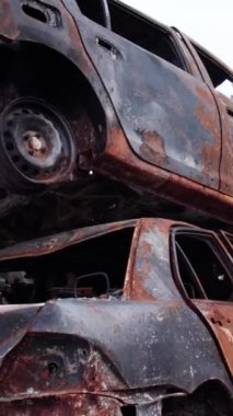 Bu stok dikey video Irpin, Bucha bölgesinde bir kurşun ve yanmış araba dökümü gösteriyor.