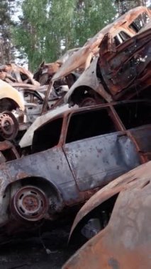 Bu stok dikey video Irpin, Bucha bölgesinde bir kurşun ve yanmış araba dökümü gösteriyor.