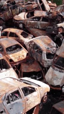 Bu stok dikey video Irpin, Bucha bölgesinde bir kurşun ve yanmış araba dökümü gösteriyor.