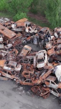 Bu stok dikey video Irpin, Bucha bölgesinde bir kurşun ve yanmış araba dökümü gösteriyor.