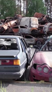 Bu stok dikey video Irpin, Bucha bölgesinde bir kurşun ve yanmış araba dökümü gösteriyor.