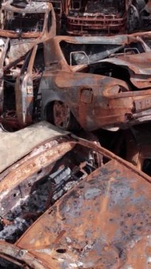 Bu stok dikey video Irpin, Bucha bölgesinde bir kurşun ve yanmış araba dökümü gösteriyor.