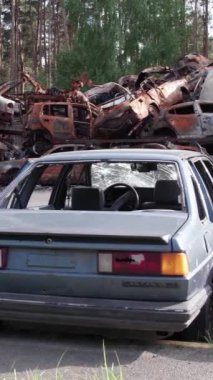 Bu stok dikey video Irpin, Bucha bölgesinde bir kurşun ve yanmış araba dökümü gösteriyor.