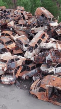 Bu stok dikey video Irpin, Bucha bölgesinde bir kurşun ve yanmış araba dökümü gösteriyor.