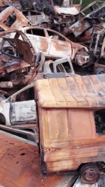 Bu stok dikey video Irpin, Bucha bölgesinde bir kurşun ve yanmış araba dökümü gösteriyor.