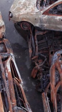 Bu stok dikey video Irpin, Bucha bölgesinde bir kurşun ve yanmış araba dökümü gösteriyor.