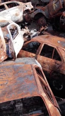 Bu stok dikey video Irpin, Bucha bölgesinde bir kurşun ve yanmış araba dökümü gösteriyor.