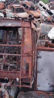 Bu stok dikey video Irpin, Bucha bölgesinde bir kurşun ve yanmış araba dökümü gösteriyor.