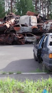 Bu stok dikey video Irpin, Bucha bölgesinde bir kurşun ve yanmış araba dökümü gösteriyor.