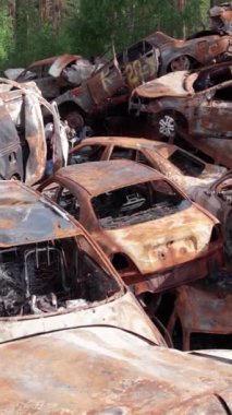 Bu stok dikey video Irpin, Bucha bölgesinde bir kurşun ve yanmış araba dökümü gösteriyor.