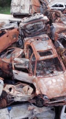 Bu stok dikey video Irpin, Bucha bölgesinde bir kurşun ve yanmış araba dökümü gösteriyor.