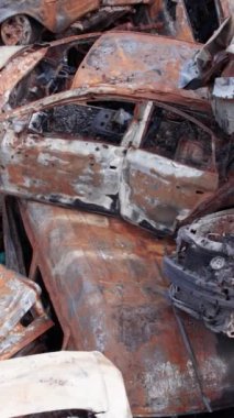 Bu stok dikey video Irpin, Bucha bölgesinde bir kurşun ve yanmış araba dökümü gösteriyor.