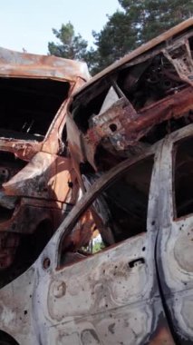 Bu stok dikey video Irpin, Bucha bölgesinde bir kurşun ve yanmış araba dökümü gösteriyor.