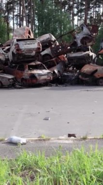 Bu stok dikey video Irpin, Bucha bölgesinde bir kurşun ve yanmış araba dökümü gösteriyor.