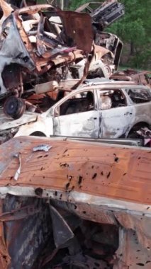 Bu stok dikey video Irpin, Bucha bölgesinde bir kurşun ve yanmış araba dökümü gösteriyor.