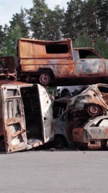 Bu stok dikey video Irpin, Bucha bölgesinde bir kurşun ve yanmış araba dökümü gösteriyor.