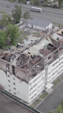 Bu borsa dikey videosu Stoyanka, Bucha bölgesinde, Ukrayna 'da, gri, renksiz, düz bir bina gösteriyor.