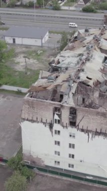 Bu borsa dikey videosu Stoyanka, Bucha bölgesinde, Ukrayna 'da, gri, renksiz, düz bir bina gösteriyor.