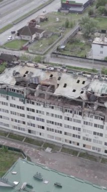 Bu borsa dikey videosu Stoyanka, Bucha bölgesinde, Ukrayna 'da, gri, renksiz, düz bir bina gösteriyor.