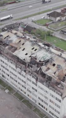 Bu borsa dikey videosu Stoyanka, Bucha bölgesinde, Ukrayna 'da, gri, renksiz, düz bir bina gösteriyor.