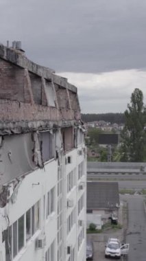 Bu borsa dikey videosu Stoyanka, Bucha bölgesinde, Ukrayna 'da, gri, renksiz, düz bir bina gösteriyor.
