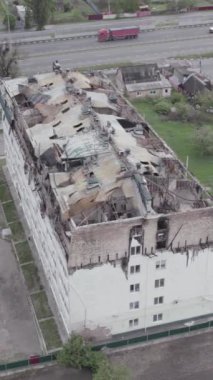 Bu borsa dikey videosu Stoyanka, Bucha bölgesinde, Ukrayna 'da, gri, renksiz, düz bir bina gösteriyor.