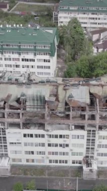 Bu borsa dikey videosu Stoyanka, Bucha bölgesinde, Ukrayna 'da, gri, renksiz, düz bir bina gösteriyor.