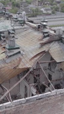 Bu borsa dikey videosu Stoyanka, Bucha bölgesinde, Ukrayna 'da, gri, renksiz, düz bir bina gösteriyor.