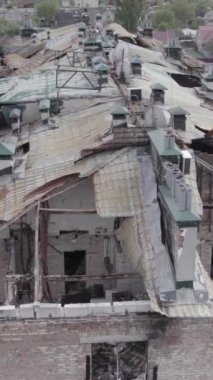 Bu borsa dikey videosu Stoyanka, Bucha bölgesinde, Ukrayna 'da, gri, renksiz, düz bir bina gösteriyor.