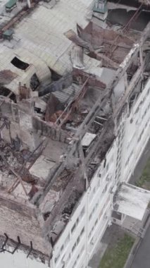 Bu borsa dikey videosu Stoyanka, Bucha bölgesinde, Ukrayna 'da, gri, renksiz, düz bir bina gösteriyor.