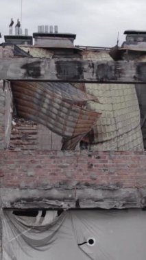 Bu borsa dikey videosu Stoyanka, Bucha bölgesinde, Ukrayna 'da, gri, renksiz, düz bir bina gösteriyor.