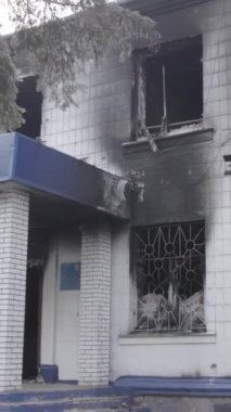 Bu dikey video Ukrayna 'daki savaşın sonucunu gösteriyor. Borodyanka, Kyiv bölgesindeki polis karakolunun yıkılmış ve yanmış binası. Gri, renksiz, düz.