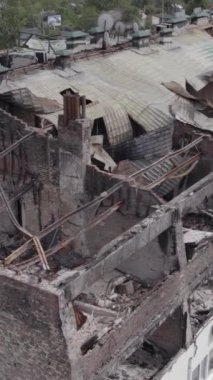 Bu borsa dikey videosu Stoyanka, Bucha bölgesinde, Ukrayna 'da, gri, renksiz, düz bir bina gösteriyor.