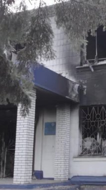 Bu dikey video Ukrayna 'daki savaşın sonucunu gösteriyor. Borodyanka, Kyiv bölgesindeki polis karakolunun yıkılmış ve yanmış binası. Gri, renksiz, düz.