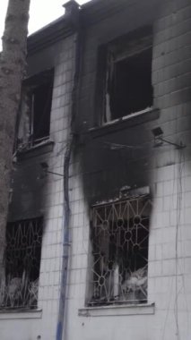 Bu dikey video Ukrayna 'daki savaşın sonucunu gösteriyor. Borodyanka, Kyiv bölgesindeki polis karakolunun yıkılmış ve yanmış binası. Gri, renksiz, düz.