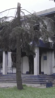 Bu dikey video Ukrayna 'daki savaşın sonucunu gösteriyor. Borodyanka, Kyiv bölgesindeki polis karakolunun yıkılmış ve yanmış binası. Gri, renksiz, düz.
