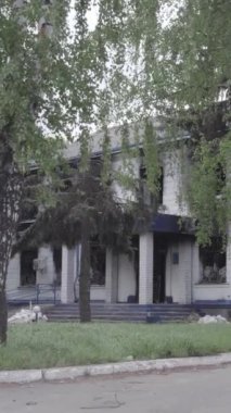 Bu dikey video Ukrayna 'daki savaşın sonucunu gösteriyor. Borodyanka, Kyiv bölgesindeki polis karakolunun yıkılmış ve yanmış binası. Gri, renksiz, düz.