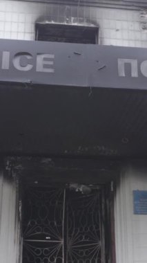 Bu dikey video Ukrayna 'daki savaşın sonucunu gösteriyor. Borodyanka, Kyiv bölgesindeki polis karakolunun yıkılmış ve yanmış binası. Gri, renksiz, düz.