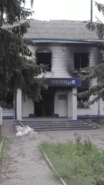 Bu dikey video Ukrayna 'daki savaşın sonucunu gösteriyor. Borodyanka, Kyiv bölgesindeki polis karakolunun yıkılmış ve yanmış binası. Gri, renksiz, düz.