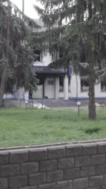 Bu dikey video Ukrayna 'daki savaşın sonucunu gösteriyor. Borodyanka, Kyiv bölgesindeki polis karakolunun yıkılmış ve yanmış binası. Gri, renksiz, düz.