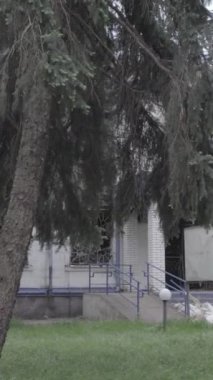 Bu dikey video Ukrayna 'daki savaşın sonucunu gösteriyor. Borodyanka, Kyiv bölgesindeki polis karakolunun yıkılmış ve yanmış binası. Gri, renksiz, düz.