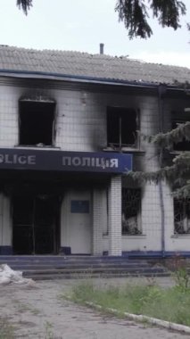 Bu dikey video Ukrayna 'daki savaşın sonucunu gösteriyor. Borodyanka, Kyiv bölgesindeki polis karakolunun yıkılmış ve yanmış binası. Gri, renksiz, düz.