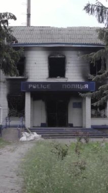 Bu dikey video Ukrayna 'daki savaşın sonucunu gösteriyor. Borodyanka, Kyiv bölgesindeki polis karakolunun yıkılmış ve yanmış binası. Gri, renksiz, düz.