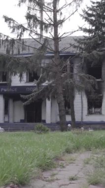 Bu dikey video Ukrayna 'daki savaşın sonucunu gösteriyor. Borodyanka, Kyiv bölgesindeki polis karakolunun yıkılmış ve yanmış binası. Gri, renksiz, düz.