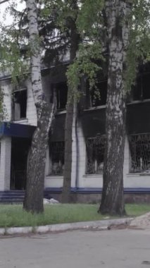 Bu dikey video Ukrayna 'daki savaşın sonucunu gösteriyor. Borodyanka, Kyiv bölgesindeki polis karakolunun yıkılmış ve yanmış binası. Gri, renksiz, düz.