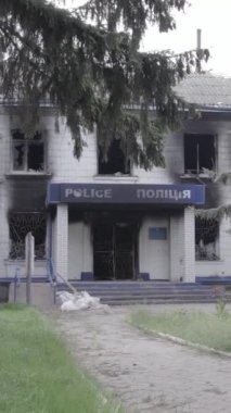 Bu dikey video Ukrayna 'daki savaşın sonucunu gösteriyor. Borodyanka, Kyiv bölgesindeki polis karakolunun yıkılmış ve yanmış binası. Gri, renksiz, düz.