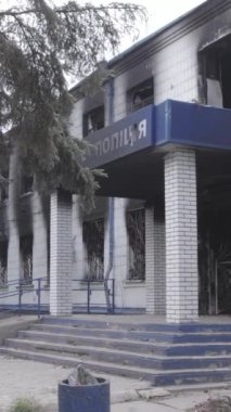 Bu dikey video Ukrayna 'daki savaşın sonucunu gösteriyor. Borodyanka, Kyiv bölgesindeki polis karakolunun yıkılmış ve yanmış binası. Gri, renksiz, düz.
