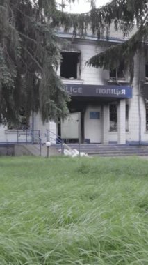 Bu dikey video Ukrayna 'daki savaşın sonucunu gösteriyor. Borodyanka, Kyiv bölgesindeki polis karakolunun yıkılmış ve yanmış binası. Gri, renksiz, düz.